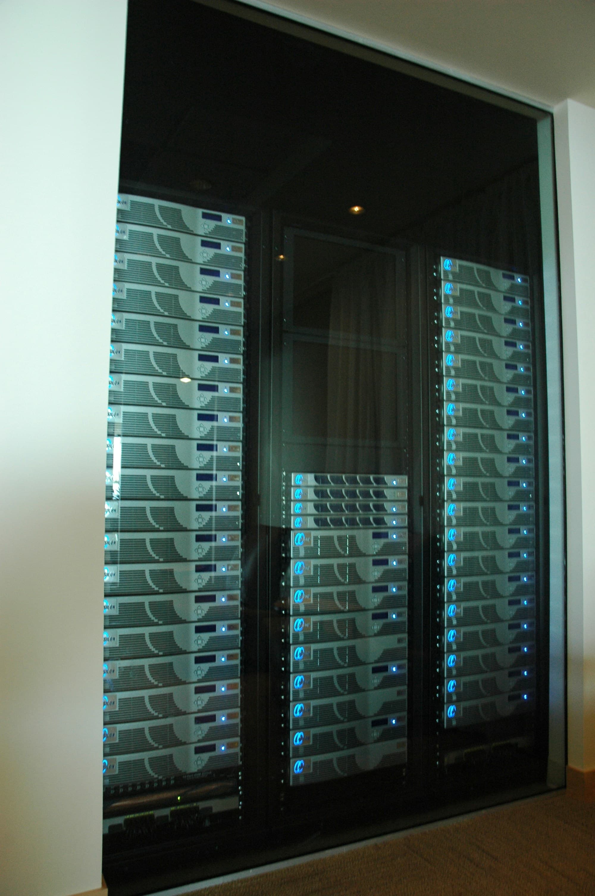 Dark server room with glowing blue rack lights in a secure data center