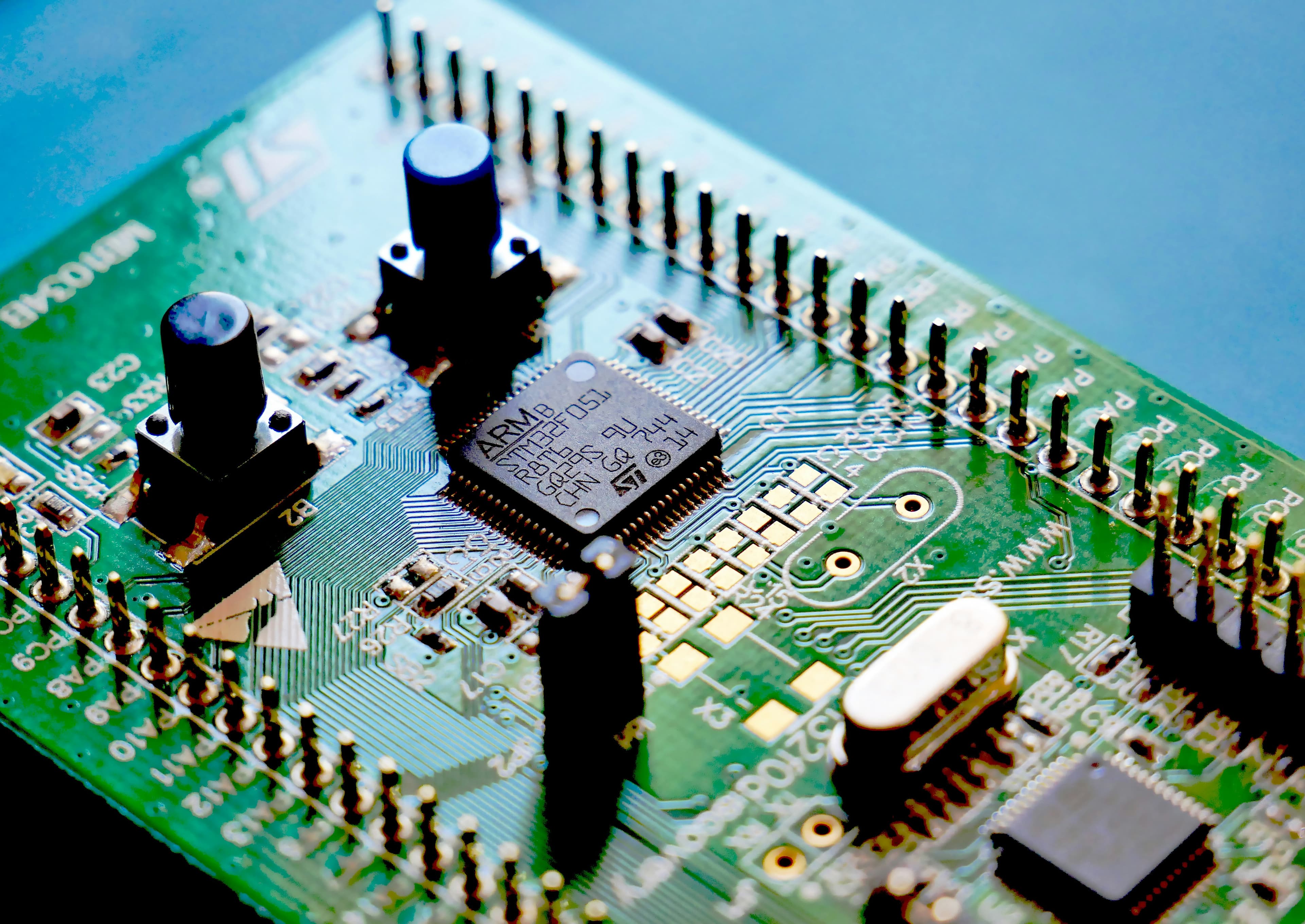 Close up of circuit board with green traces and microchip components